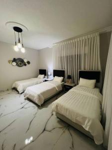 亚喀巴Luxury 4-bedrooms apartment的一间卧室配有两张带白色床单的床