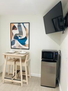 迈阿密Nuvole Guest Suite的厨房配有桌子、微波炉和电视。