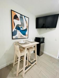 迈阿密Nuvole Guest Suite的一张桌子、两把椅子和一台电视机