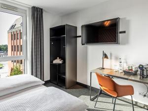 吕贝克吕贝克住宿加早餐旅馆的配有一张床、一张书桌和一扇窗户的酒店客房