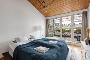 赫尔辛基WeHost Penthouse Studio with Sauna and Balcony @Meritullinkatu 13 A的一间卧室配有一张床,上面有两条毛巾