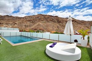 莫甘Villa Tauro 31的一个带游泳池、遮阳伞和草地的庭院