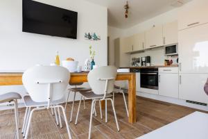 奥茨塞巴德·迪尔哈根DER STÖRTEBEKER - "Apartment Born" Apartments hinter den Dünen的厨房配有白色的椅子和木桌