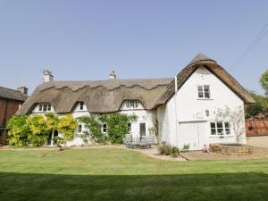 拉特沃思Millstone House的一座带茅草屋顶的大型白色房屋