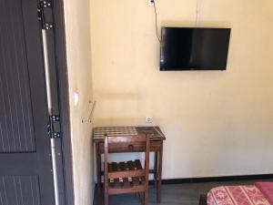 希莫尤Residencial Meu Tio的一间房间,墙上设有一张桌子和一台电视机