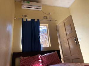 希莫尤Residencial Meu Tio的一间卧室配有一张带蓝色窗帘的床和窗户