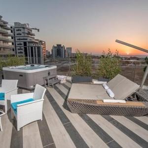 哈德拉Architect beach house的一个带桌椅的屋顶露台和热水浴池