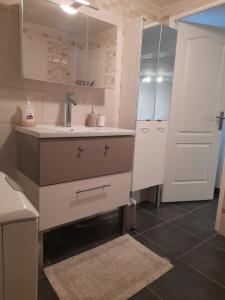 新城勒鲁瓦Appartement proche d'Orly的厨房配有白色橱柜、水槽和门