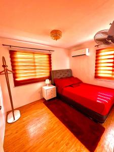 巴科洛德Two-Bedroom Townhouse Camella Bacolod South的一间卧室设有红色的床和2个窗户。