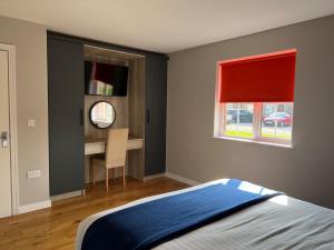 安特里姆斯特布尔考特公寓酒店的一间卧室配有一张床、一张书桌和一个窗户。