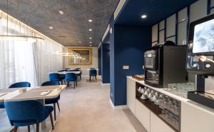 里斯本AMMA Lisboa Hotel的餐厅拥有蓝色的墙壁和桌子以及蓝色的椅子