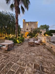 莱切Tenuta Monacelli Lecce的城堡前带躺椅的石头庭院