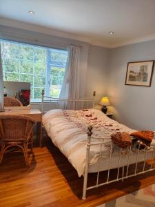 MerstonBracken Lodge的一间卧室配有一张床、一张桌子和一个窗户。