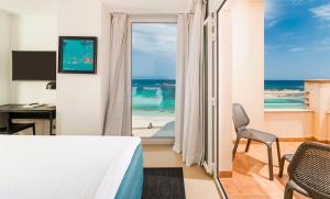 埃斯普霍斯Hotel Tahiti的一间卧室配有一张床,享有海滩美景