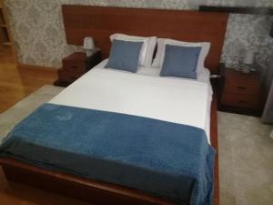 蒙蒂茹Apartamento da Aldeia的一间卧室配有一张带蓝色枕头的大床