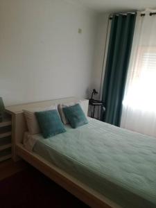 蒙蒂茹Apartamento da Aldeia的卧室内的一张带两个蓝色枕头的床