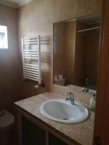 蒙蒂茹Apartamento da Aldeia的一间带水槽、镜子和卫生间的浴室