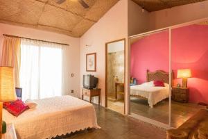 巴亚尔塔港Casa La Columna的一间卧室设有两张床和粉红色的墙壁
