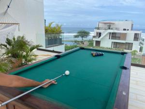 托拉Hacienda Iguana beach front Penthouse with swimming pools and ocean view的在房子阳台上打台球的人