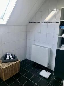 兹沃勒Westenholte的白色瓷砖浴室设有卫生间和水槽