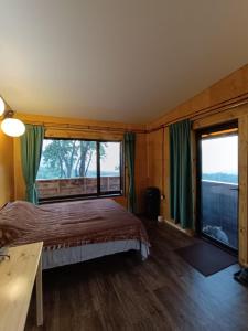 阿拉木图Янтарь Уютный горный домик的一间卧室设有一张床和一个大窗户