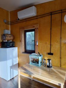 阿拉木图Янтарь Уютный горный домик的一间带桌子和冰箱的小厨房