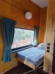 阿拉木图Янтарь Уютный горный домик的卧室设有窗户,卧室内设有一张床