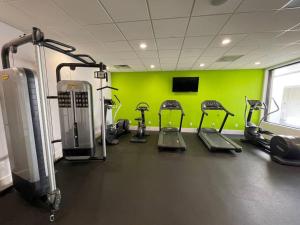 基西米Newly renovated room in cozy hotel near Disney的健身房设有数台跑步机和绿色墙壁