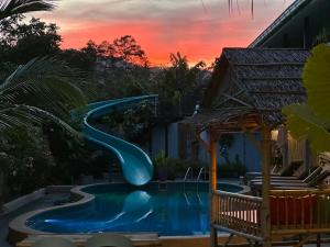 湄南海滩Samui Zenity的游泳池的滑梯,背景是日落