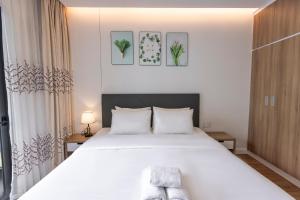 胡志明市Republic Apartments Saigon Airport的一间卧室配有一张带白色床单的大床