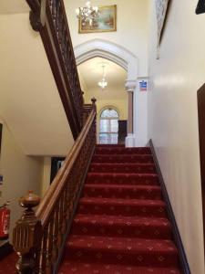 班伯里利斯莫尔酒店的一条铺有红地毯的楼梯和一个楼梯箱