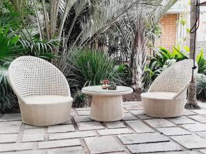 塔那那利佛维兰格酒店的植物庭院里的两把椅子和一张桌子
