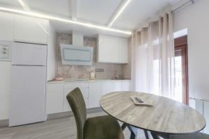 比利亚卡里略VTAR Puerta Del Sol的白色的厨房配有木桌和椅子