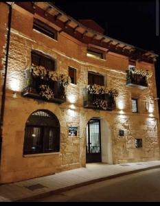 Tudela de Duero拱门酒店的砖砌建筑,有窗户和盆栽植物