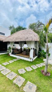 邦劳Panglao Lofts的草屋顶和棕榈树的房子
