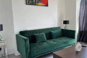 纽波特Captivating 1-Bed Apartment in Newport的客厅配有一张绿色沙发,设有一张桌子