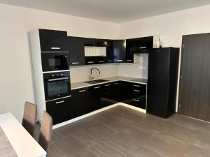 布拉格Byt apartman 73m2 for 4people ALL NEW! 2023的厨房配有黑白电器和桌子