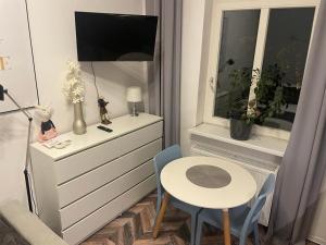卡托维兹Apartment Katowice Center-1的小房间设有书桌、桌子和窗户