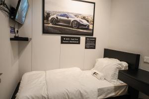 丹绒道光FAST FIVE At Gurney的一间房间,配有一张床,墙上挂着一幅汽车照片