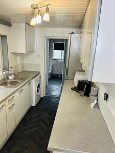 吉林汉姆Great Accommodation in Medway的厨房配有水槽、洗衣机和烘干机
