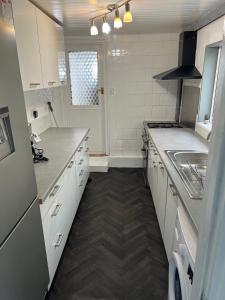 吉林汉姆Great Accommodation in Medway的厨房配有白色橱柜和水槽