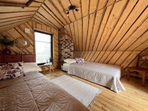 SaulaMetsakuurorti puhkekeskus, Mummila house的一间带两张床的卧室,位于木天花板的房间