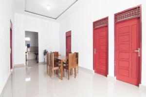 ParitOYO 93088 Celine Home Syariah的一间设有红色门和桌子的用餐室