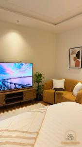 利雅德Modern studio with self check-in的客厅配有平面电视和沙发。