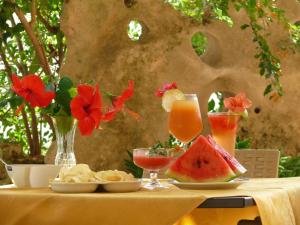兰佩杜萨Alba D'Amore Hotel & Spa的桌上放着食物和饮料的桌子,花朵