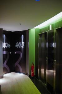 戈亚尼亚Hotel Black Inn Flamboyant的一间设有绿色和黑色墙壁的客房,并设有电梯。