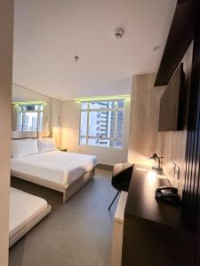 戈亚尼亚Hotel Black Inn Flamboyant的酒店客房配有两张床和一张书桌