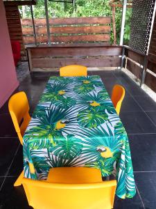波拉波拉Bora Rent lodge的一张桌子,上面摆放着黄色椅子,还有彩色的桌布