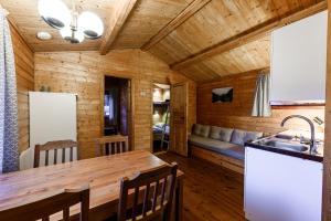 IsfjordenKorsbakken Camping的小木屋的厨房和用餐室,拥有木制天花板