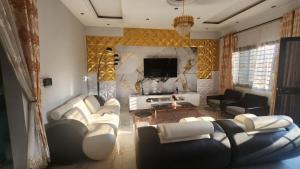 雅温得Résidence Deluxe的客厅配有白色沙发和电视